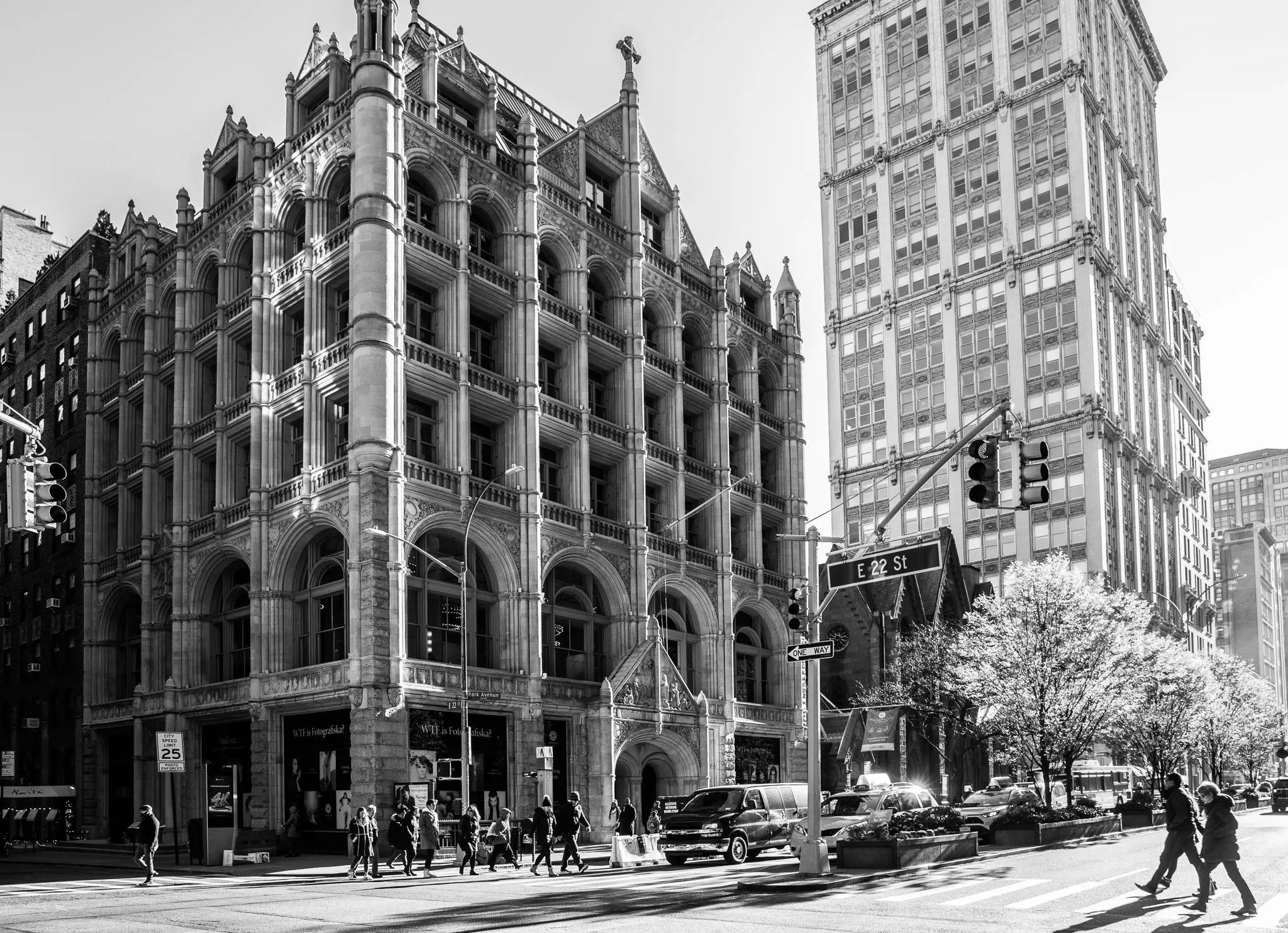 Black & white image of the building in romanesque revival style where Fotografiska New York hold residency 2019-2024. People crossing the street in foreground. 